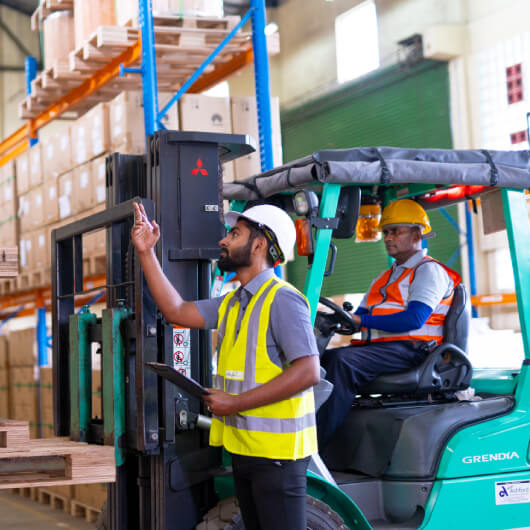 Warehouse workers loading cargo on a forklift